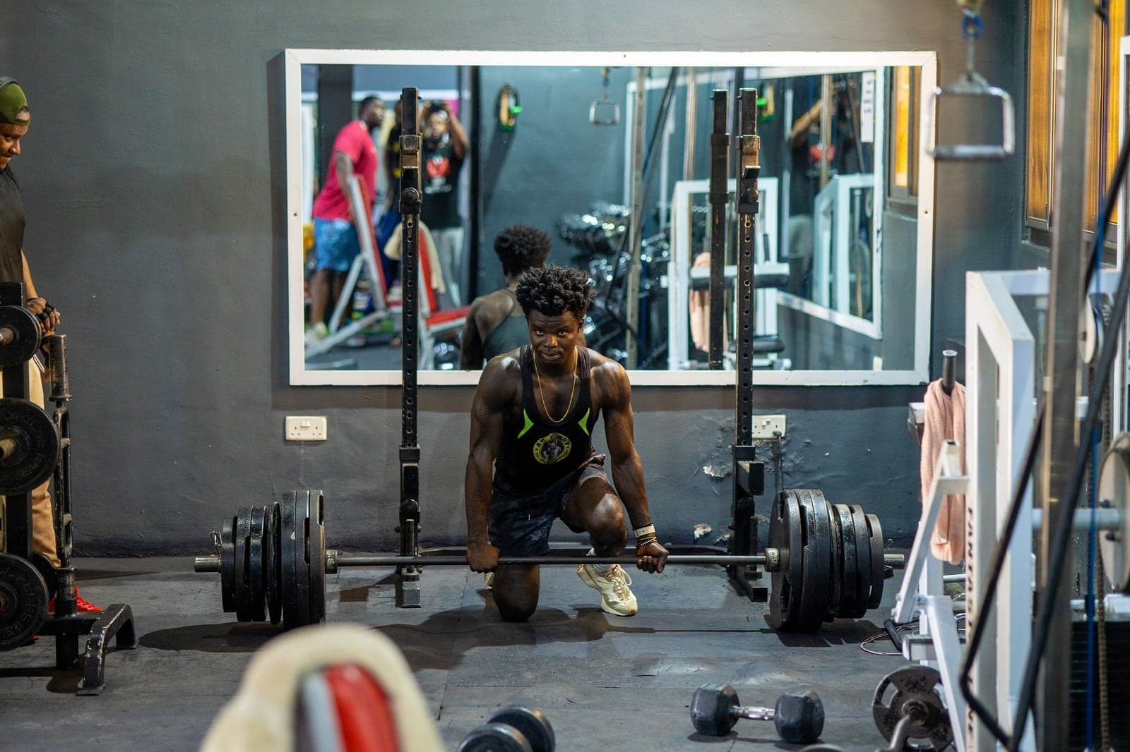 A member preparing a loaded barbell on the strength floor